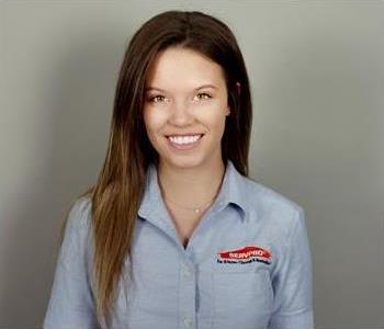 SERVPRO female employee standing in front of grey wall