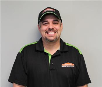 Servpro male employee standing in front of grey wall